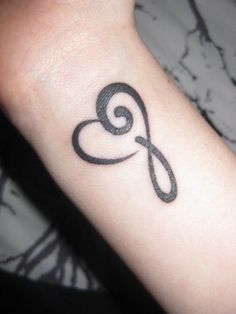 a black and white tattoo on the arm of a woman's wrist with an infinite symbol