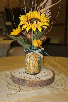 a mason jar filled with sunflowers on top of a table