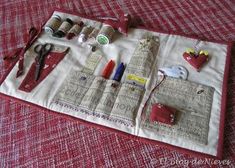 sewing supplies laid out on top of a red and white table cloth with scissors, thread spools