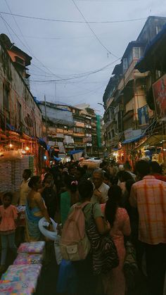 many people are walking through an outdoor market