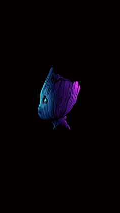 a blue and purple fish floating in the dark