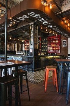 the inside of a restaurant with tables and stools