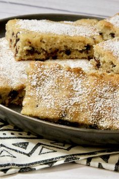 several pieces of cake on a plate with powdered sugar