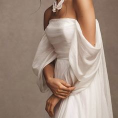 a woman wearing a white dress and pearls