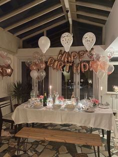 a table with balloons, plates and cups on it