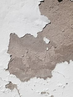 an old wall with peeling paint and chipping off the top part, showing cracks in it