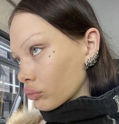 a woman with piercings on her nose looking at the camera