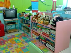 there are many stuffed animals on the shelves in this children's playroom area