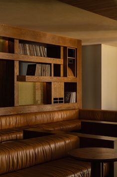 an empty room with leather couches and bookshelves