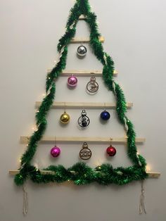 a christmas tree made out of wooden boards with ornaments hanging from it's sides