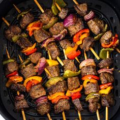 the skewers are being cooked on the grill with peppers, onions and meat