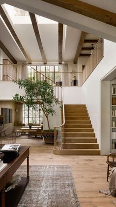 a living room filled with lots of furniture and a tree in the middle of it