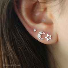 a woman's ear with two stars and a moon on it