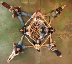 a group of people standing in the middle of a star shaped structure with their hands together