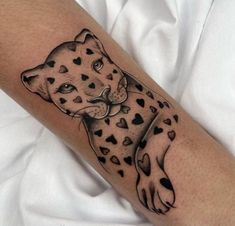 a black and white tattoo of a cheetah with hearts on it's arm