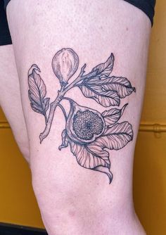 a woman's leg with a tattoo on it that has a flower and leaves