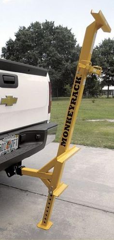 a white truck parked in front of a yellow hitch - up to the back of it's bed