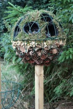 a bird feeder filled with pine cones and plants