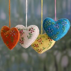 three heart shaped ornaments hanging from strings