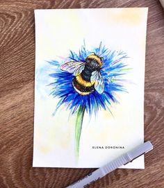 a watercolor painting of a bee sitting on a blue flower next to a marker