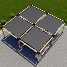 an aerial view of a table made out of four pieces of wood and fabric, with grass in the background