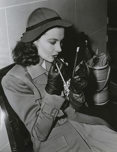 a woman wearing gloves and holding a pipe