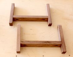 two wooden shelves sitting on top of a table next to each other with one missing