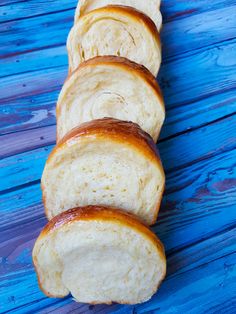 several loaves of bread sitting on top of a blue wooden table next to each other