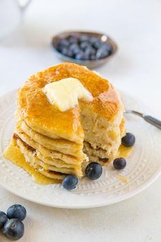 a stack of pancakes with butter and blueberries