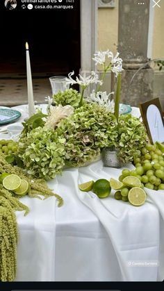 the table is set with limes, grapes and other fruits on it for a celebration