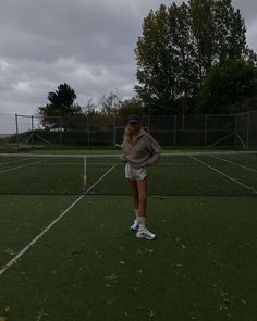 a woman standing on top of a tennis court holding a racquet in her hand