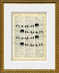 an old book page with birds sitting on clothes pins, framed in gold frame and white mat