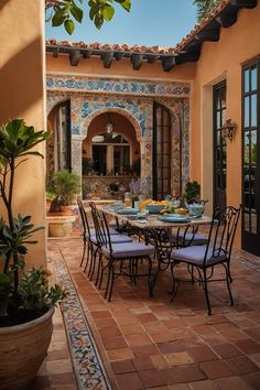 an outdoor dining area with tile flooring and potted plants on the side walk