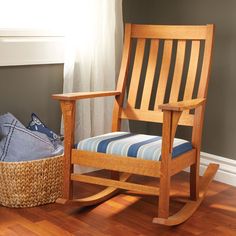 a wooden rocking chair sitting on top of a hard wood floor next to a basket