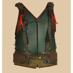 the back view of a green leather vest with red straps and zippers on it