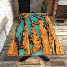 a table made out of wood with blue water in the center and black metal legs