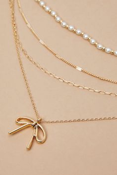 Add a dash of charm to your look with our super dainty and adorable necklace featuring a bow charm and delicate pearl detailing. This elegant accessory exudes timeless beauty, perfect for effortlessly elevating any ensemble with its whimsical and graceful allure. Bow Necklace, Birthday Wishlist, Accessories Jewelry Necklace, Elegant Accessories, Altar'd State, Sweater Sale, Gold Pearl, Timeless Beauty, Pearl Necklace