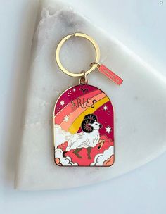 a keychain with an image of a dog on it and the words aries