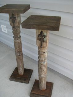 two wooden tables with crosses on them sitting in front of a white wall and door