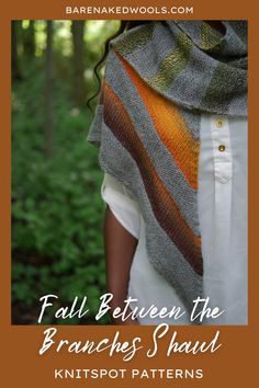 a woman is standing in the woods wearing a shawl with stripes on it and holding her hands behind her back