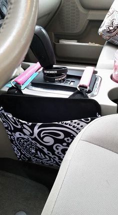 the interior of a car with a cell phone and various other items in its holder