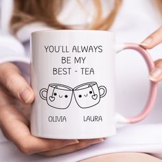 a woman holding a coffee mug with two faces on it and the words you'll always be my best - tea