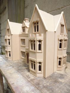 two model houses sitting on top of a wooden table next to each other and one is made out of clay