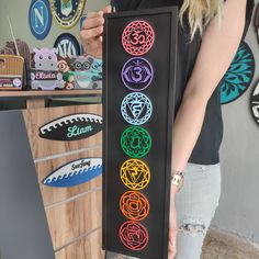 a woman holding up a sign with seven chakras on it