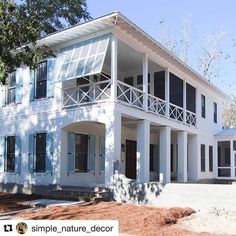 a large white house sitting on top of a dirt field