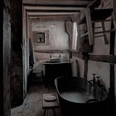 an old fashioned bathtub and sink in a rustic bathroom