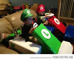 two boys in mario bros costumes sitting on couches with boxes and cups around them