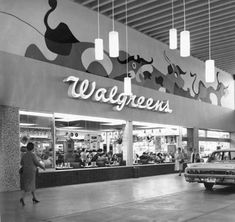 an old black and white photo of a walgrees store