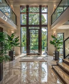 an elegant foyer with marble floors and large windows, surrounded by potted greenery