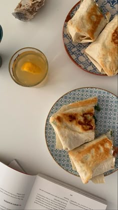 two plates filled with food next to an open book